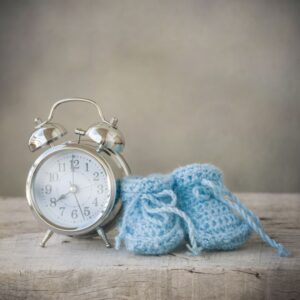relógio despertador com sapatinho de bebê de tricot azul